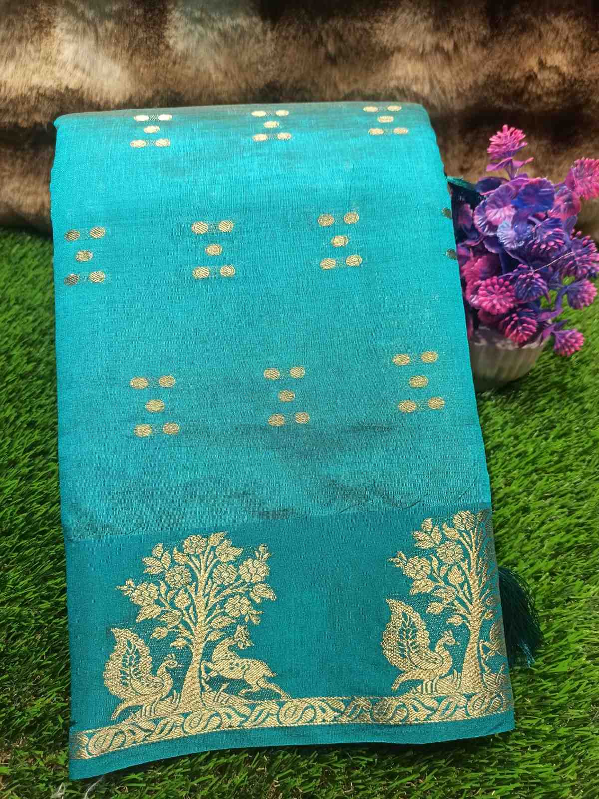Turquoise saree with gold patterns on a green grass background