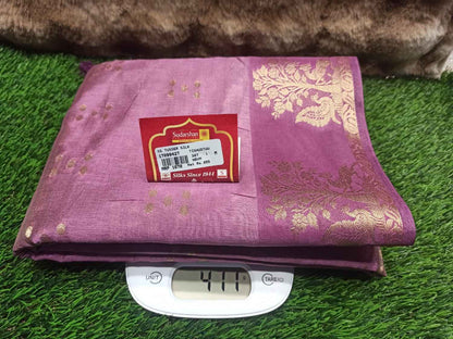 Purple fabric with gold patterns on a digital scale against a grassy background