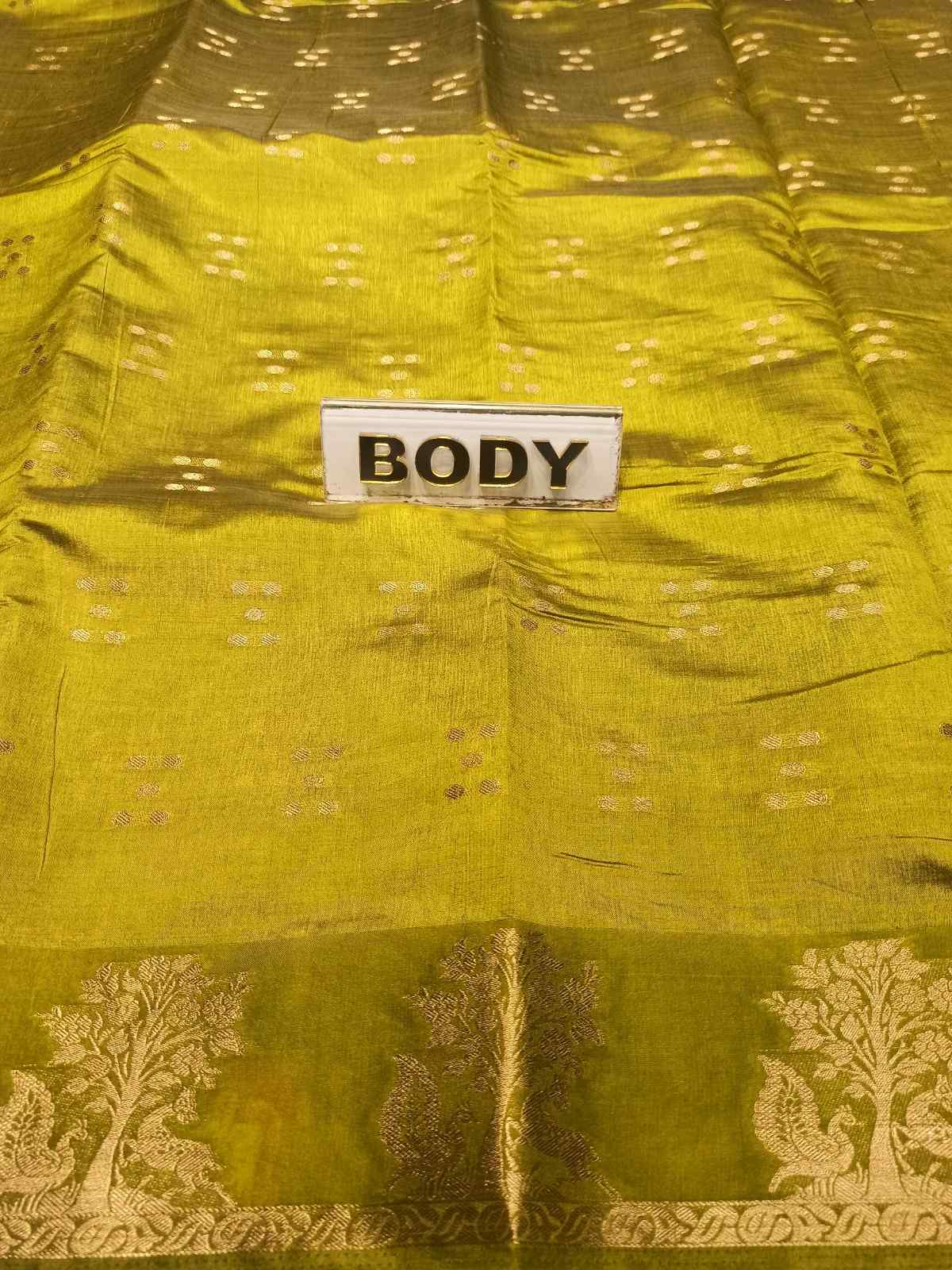 Close-up of a green fabric with a 'BODY' label and intricate patterns.