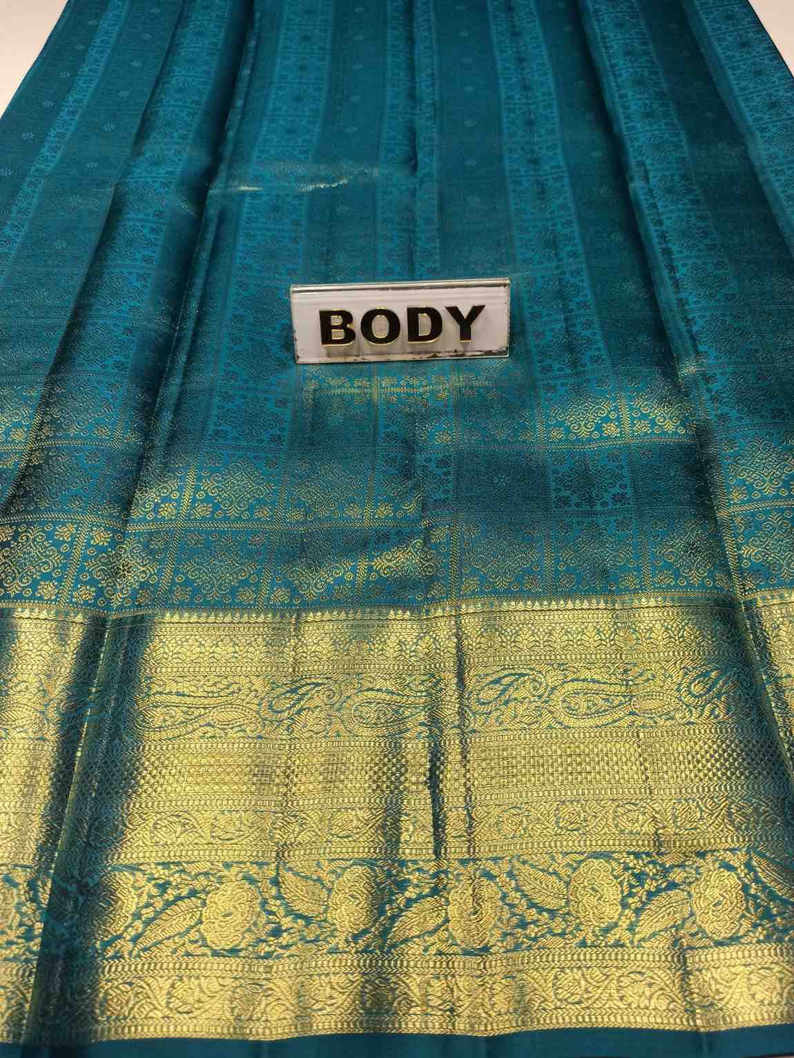Teal fabric with gold patterns and a label labeled 'BODY'.