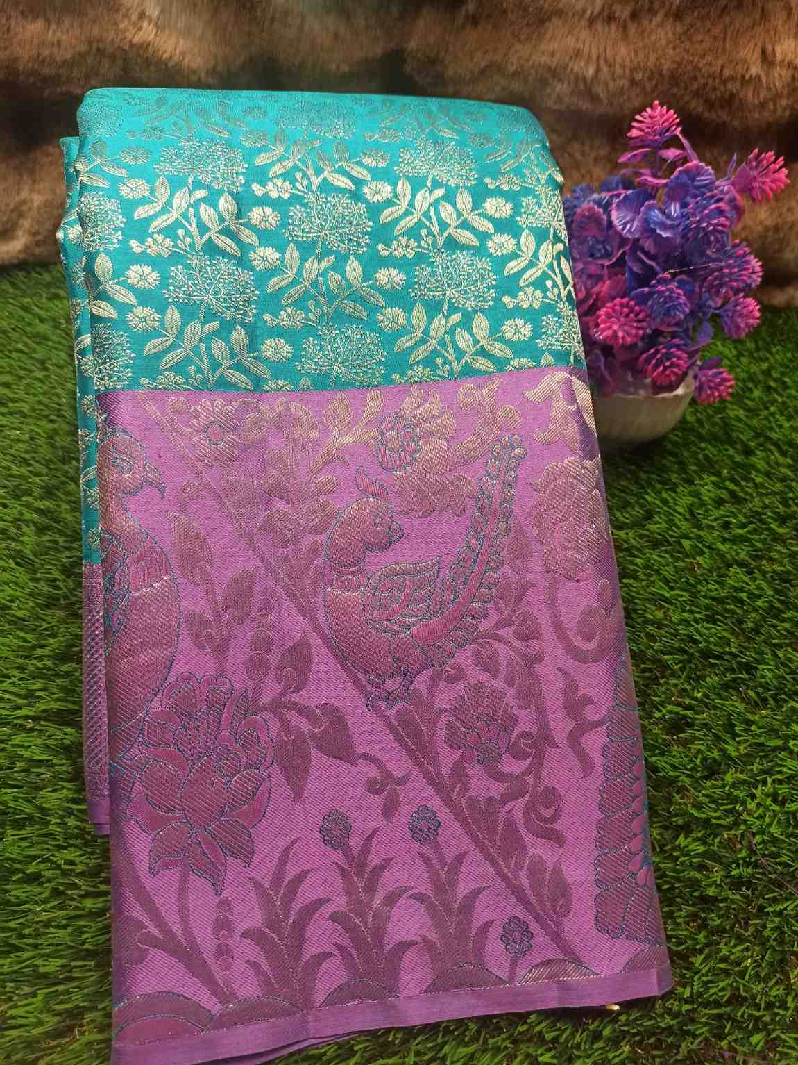 Two fabric samples, one turquoise and one purple with floral patterns, on a grassy background.