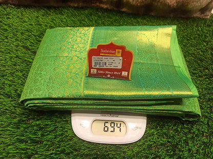 Green fabric with a label on a digital scale on a grass-like surface