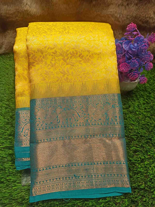 Yellow and blue saree with intricate patterns on a green surface