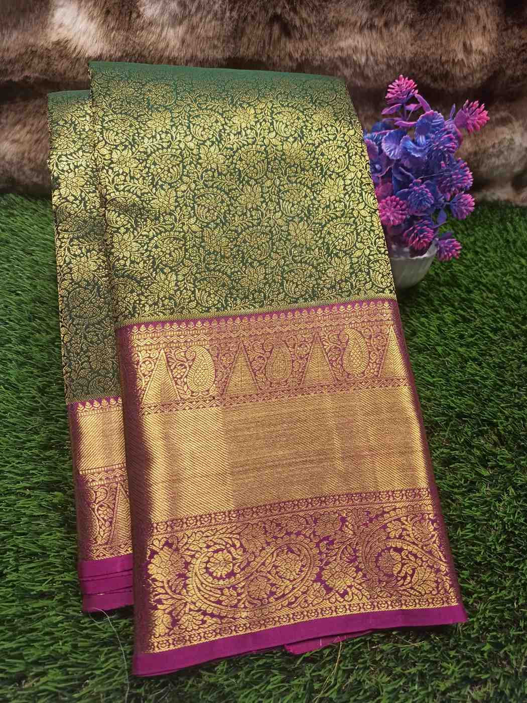 Green and gold saree with purple border on grass