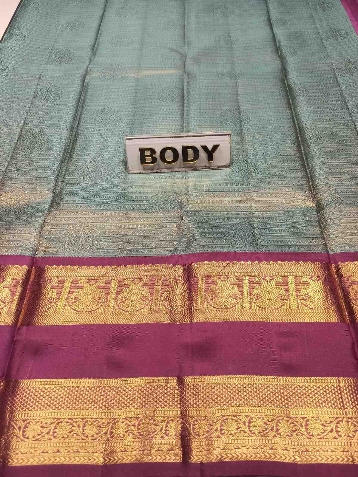 Teal and purple saree with gold border and 'BODY' label.